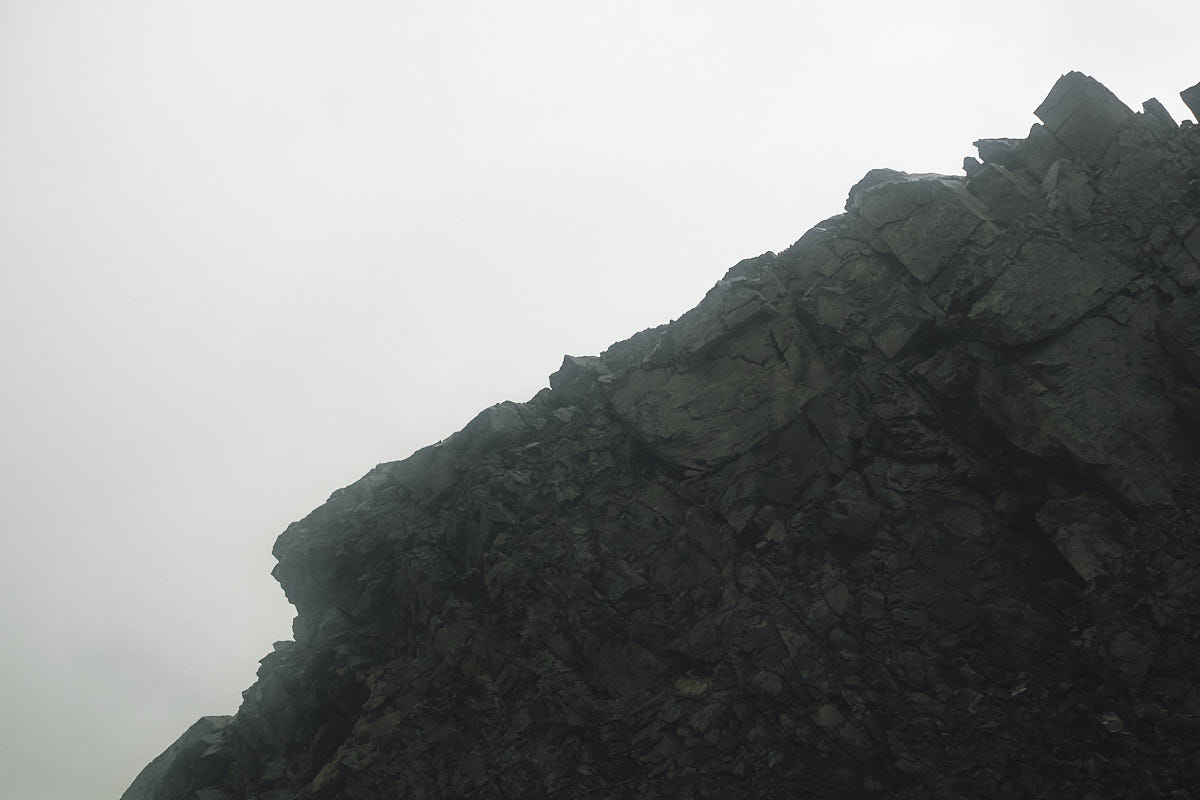 Black and white close-up of a rock formation, contrasting against a bright sky